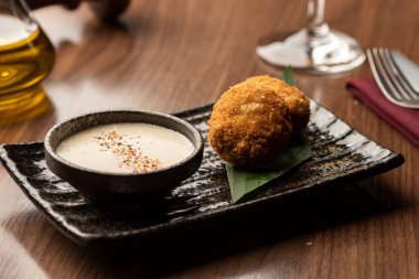 Peynirle doldurulmuş kızarmış toplar ve arka planda bulanık Tayland yemeğiyle kızartılmış soslar.
