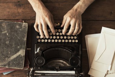 Antika bir vintage daktiloda yazmaya genç adamın elleri