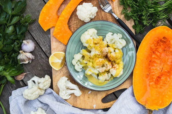 Steamed cauliflower with sauce and pumpkin and greenery Stock Picture