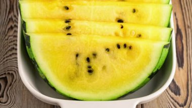 Tabakta taze sarı karpuz dilimleri.