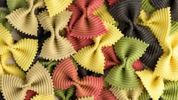 Colored bow tie pasta. Closeup multiple farfalle on white background. — Stock Video