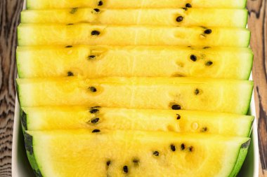 Tabakta taze sarı karpuz dilimleri.