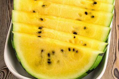Tabakta taze sarı karpuz dilimleri.