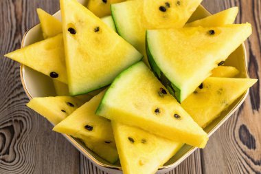 Tabakta taze sarı karpuz dilimleri.