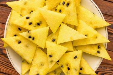 Tabakta taze sarı karpuz dilimleri.