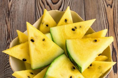 Tabakta taze sarı karpuz dilimleri.