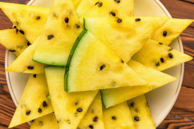 Tabakta taze sarı karpuz dilimleri.