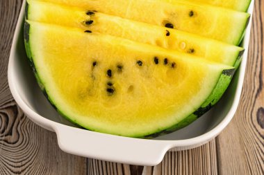 Tabakta taze sarı karpuz dilimleri.