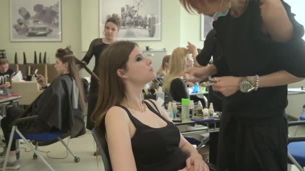 Las modelos hacen el maquillaje y el peinado antes de comenzar el desfile de moda SEMILETOVA. — Vídeos de Stock