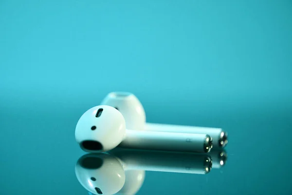 Dramatische Aufnahme Weißer Drahtloser Kopfhörer Airpods Auf Blauem Hintergrund Gibt lizenzfreie Stockbilder