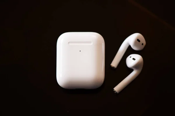 ボックスと耳栓付きの白い色のエアポッド 無線イヤフォン これは隔離された黒い背景にあります ストック画像