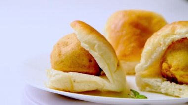 Pav (ekmek) ve kızarmış patatesli Vada pav Hint fast food tabağı. Beyaz plaka dönüşümlü Vada pav