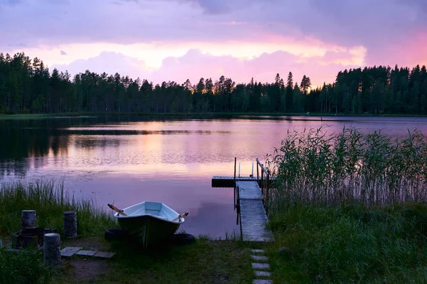 夏季日落的芬兰湖岸边 一个小码头和一条小船 — 图库照片