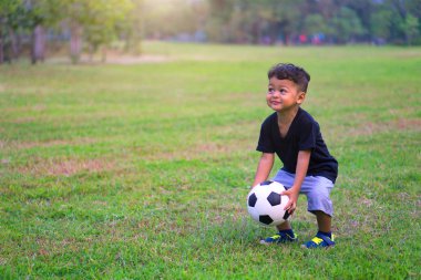 Asyalı çocuk futbol veya parkta futbol oynarken.