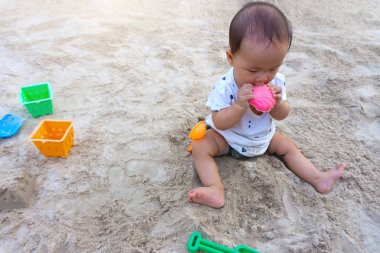 Asya toddler bebek Taylandlı kız parkta kum ile oynarken.