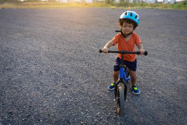 Asyalı çocuk ilk gün oyun denge bisikleti. Küçük çocuk bisiklet ile binmek için öğrenme. 