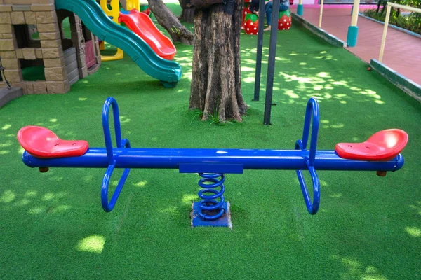 Teeterboard azul en blanco en el parque infantil en el jardín —  Fotos de Stock