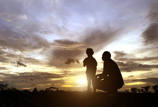 Die Silhouette des Vaters und des Sohnes, die den Sonnenuntergang — Stockfoto