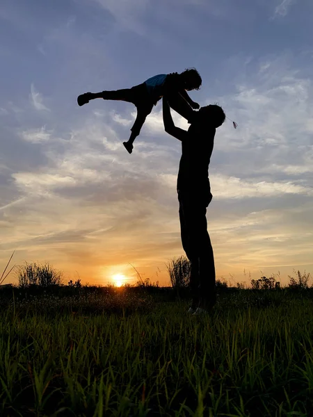 Silhouette Vater trägt Sohn bei Sonnenuntergang gegen den Himmel — Stockfoto