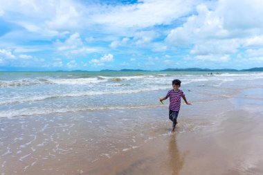 Asyalı çocuk yaz tatillerinde Phala Sahili, Ban Chang Bölgesi, Rayong, Tayland 'da oynamaktan zevk alıyor..