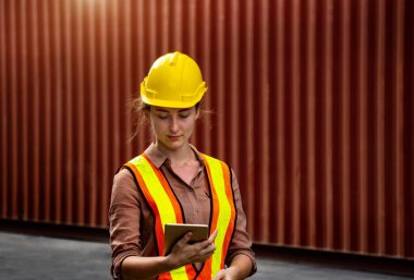 Kadın ustabaşı endüstriyel sektördeki işleri kontrol etmek için bilgisayar tableti kullanıyor.