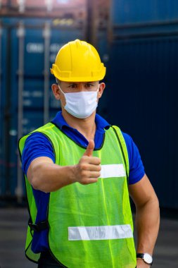 Nakliye endüstrisindeki erkek işçilerin fabrikada Covid 19 virüsünün yayılmasını önlemek için hijyenik maskeleri var..