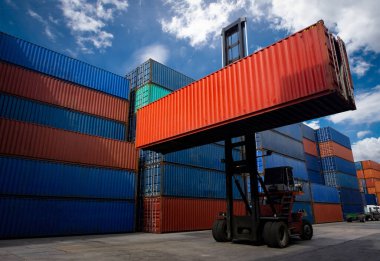 Nakliye endüstrisinde konteynır kutusu taşıyan bir forklift ve depo deposunda kargo işi..