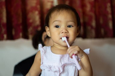11 aylık bir kız. Annesinin öğretmeninden diş fırçası kullanıyor..