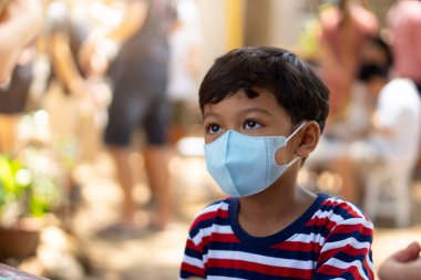 Asyalı çocuk okullarda Coronavirus 2019 (COVID-19) hastalığını önlemek için yüz maskesi takıyor.