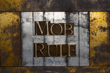 Photo of real authentic typeset letters forming Mob Rule text on vintage textured silver grunge copper and gold background clipart