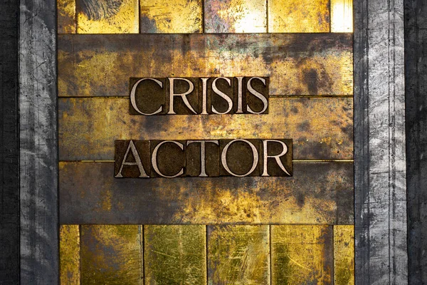 Crisis Actor text formed with real authentic typeset letters on vintage textured silver grunge copper and gold background