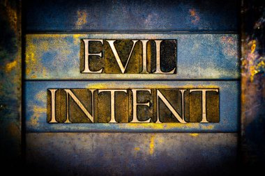 Evil Intent text formed with real authentic typeset letters on vintage textured silver grunge copper and gold background clipart