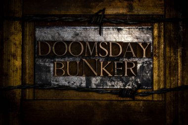 Doomsday Bunker metni, klasik desenli gümüş grunge bakır ve altın arkaplan üzerine hakiki yazı dizisi harfleriyle oluşturuldu