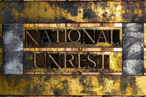 ナショナルアンレストテキストは ヴィンテージテクスチャグランジ銅と金の背景に有刺鉄線と本物のタイプセット文字によって形成 — ストック写真