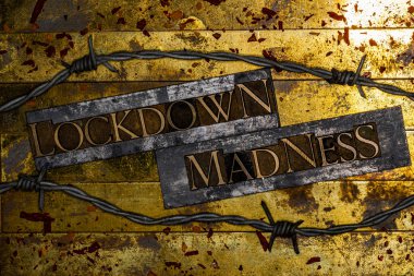 Lockdown Madness text message on textured grunge copper and vintage gold background with barbed wire and red viral particles  clipart
