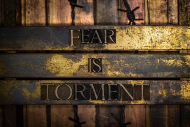 Fear is Torment text message on textured grunge copper and vintage gold background with barbed wire clipart