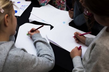 İki liseli kız boş kağıtlara yazı yazıyor..