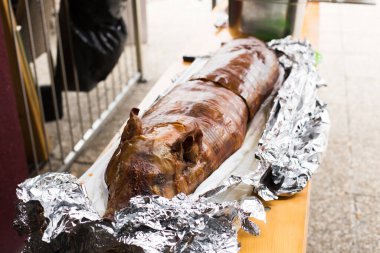 Izgara domuz yavrusu. Derisi hala alüminyum folyoya sarılı..
