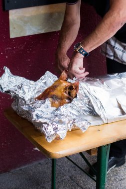 Izgara domuz yavrusu. Derisi hala alüminyum folyoya sarılı..