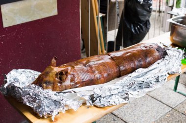 Izgara domuz yavrusu. Derisi hala alüminyum folyoya sarılı..