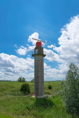 Antik Doel, Belçika 'daki Radar Kulesi. Yeşil bir çevresi ve bulutlu mavi bir gökyüzü var.
