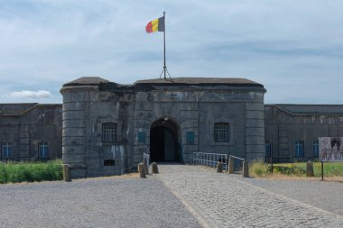 Breendonk, Belçika, 22 Temmuz 2019. Belçika bayrağıyla Breendonk Kalesi 'nin karanlık girişi veya ulusal anıtı.