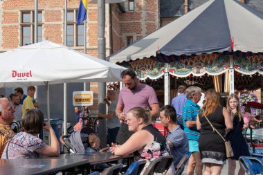 3 Ağustos 2019 'da Sint Gillis Waas, Belçika' da bir festivalde masaya oturan müşterilerin siparişlerini alır.