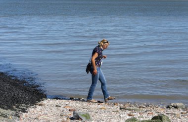 Walsoorden, Hollanda, 15 Ağustos 2019 Kadınlar Walsoorden sahilindeki suya doğru yürür.