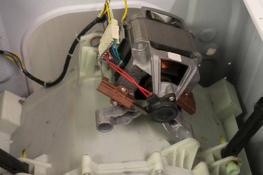 Karbon fırçalarının bağlı olduğu bir çamaşır makinesinin motoru.