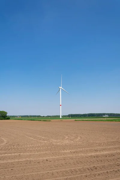 Turbina Eólica Junto Campo Arado Con Hermoso Fondo Azul — Foto de Stock