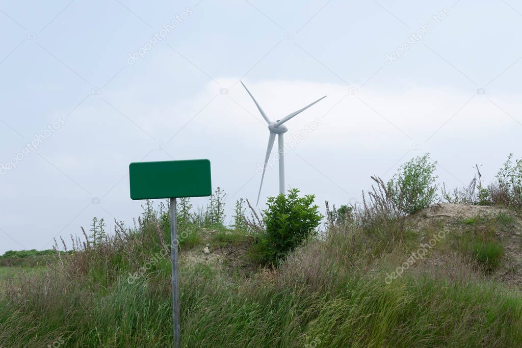 windmill in the dunes of sealand and the empty Board in the foreground