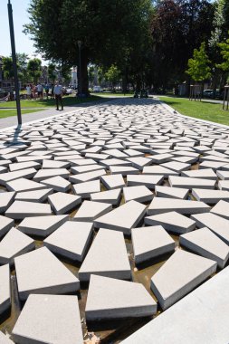Lokeren, Belçika, 13 Temmuz 2020, çokgen prizma taşları çeşme, su ve turistler geçiyor.