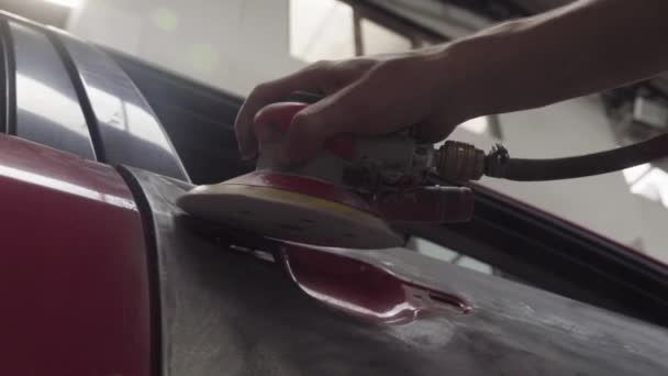 修理工给撞坏的带有音轨的汽车罩打沙 — 图库视频影像