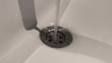 Akan su küçük kirli bir lavaboya dökülüyor, sesle.